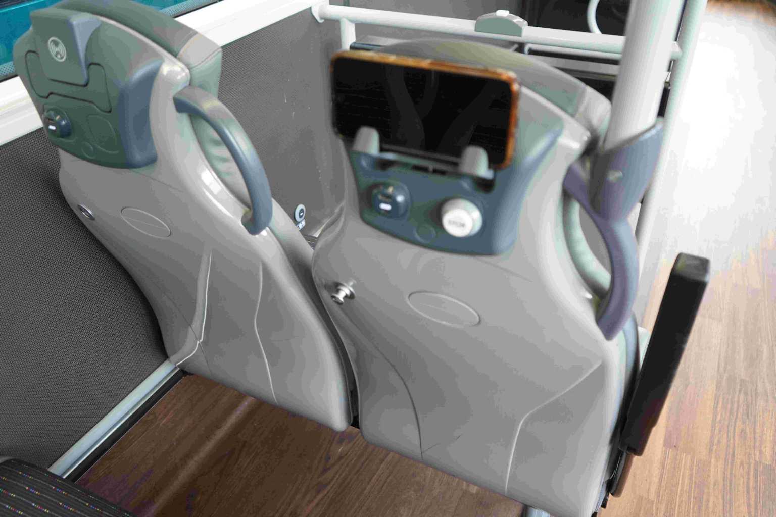 a seat back with a phone in a charging cradle