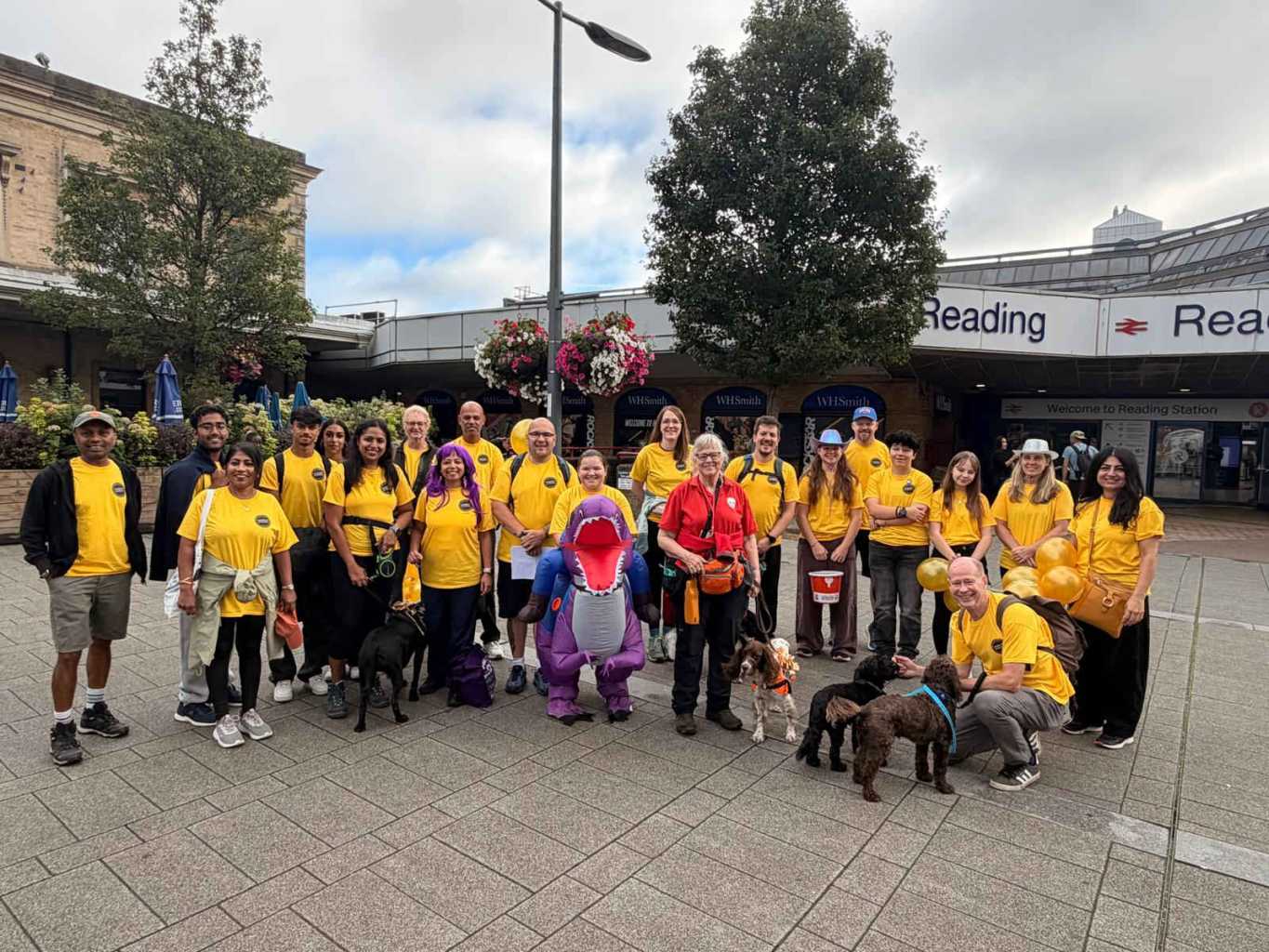 group in bright t shirts in front of Reading Station