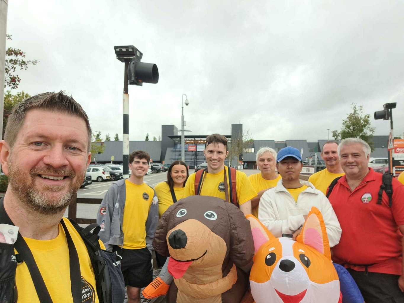a group picture in front of Sainsbury's Calcot. Two people are wearing inflatable dog costumes