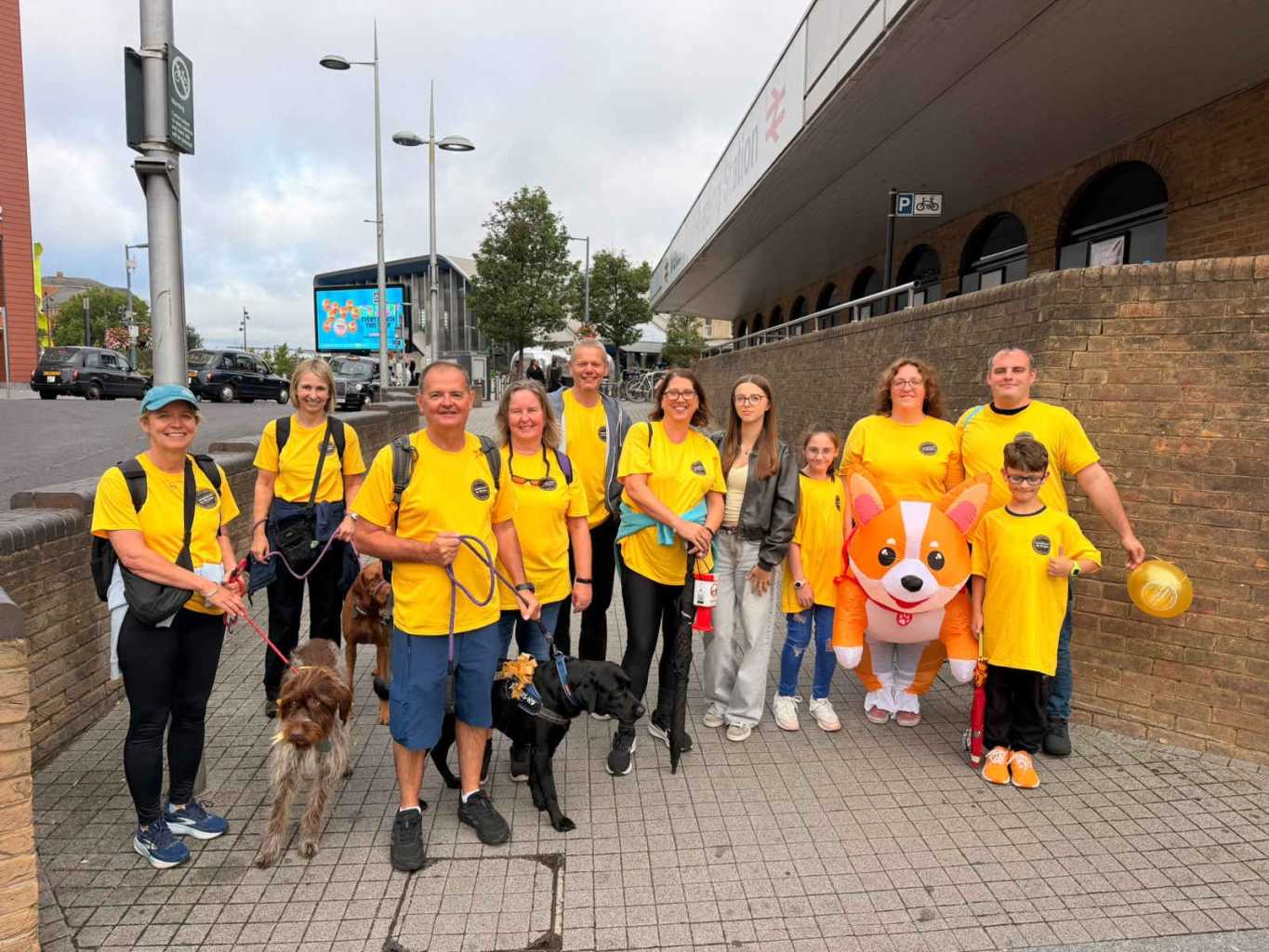 a team of people with bright t shirts and an inflatable dog costume