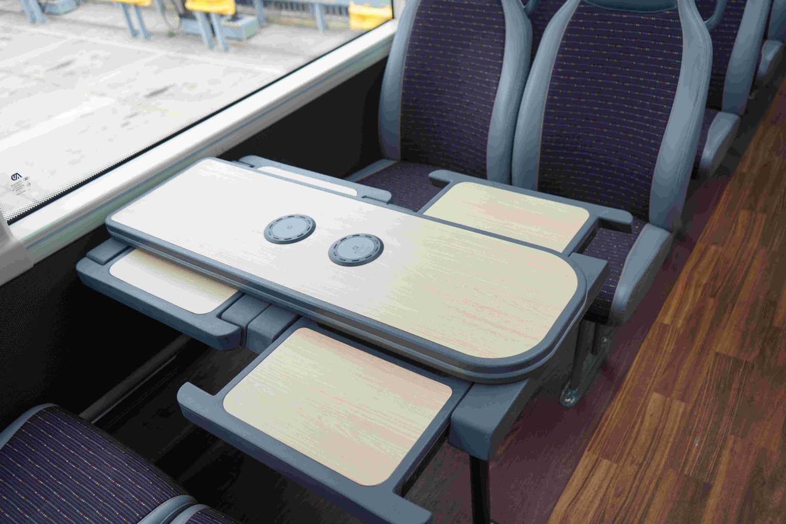 a table on the bus with fold out sections and two air charge points